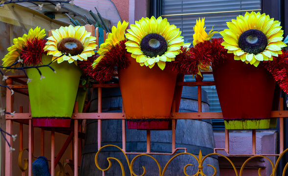 Decorative artificial sunflowers inside flower pots on home balcony