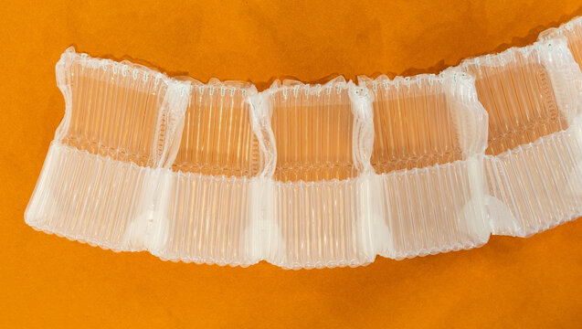 plastic translucent air packaging, protection of goods on orange background