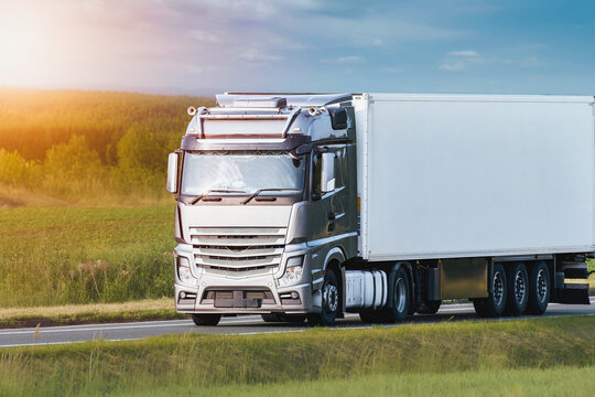 Clean white semi truck driving through forest