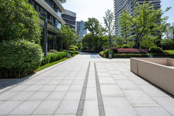 Modern residential area with landscaped walkway surrounded by greenery and high-rise buildings © zhu difeng