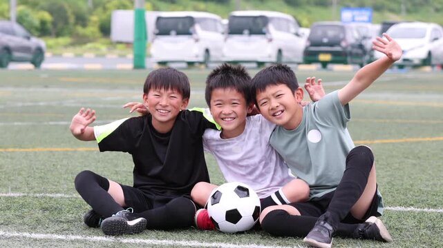 笑顔で肩を組む少年サッカーチームの仲間たち