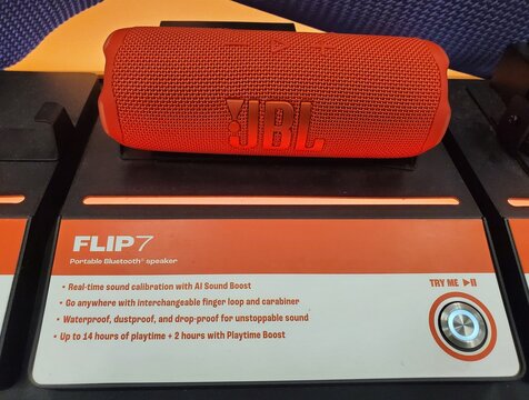 Wilmington, Delaware, U.S.A - May 5, 2026 - A red JBL Flip7 Bluetooth speaker displayed with features including AI sound boost, waterproofing, and extended playtime.