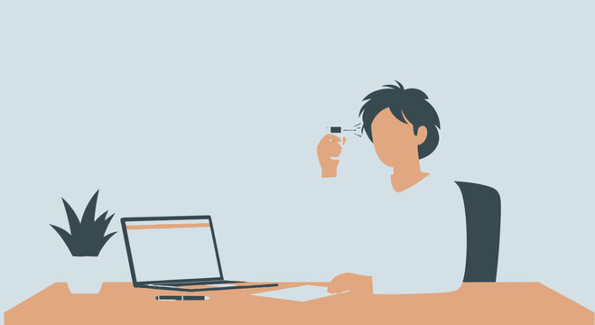 A Person Using a Device Over Their Eye Next to A Laptop on the Table to Work, Focused