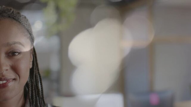 Woman reacting to offcamera cue in interview, smiling laughing calming with bokeh avoiding face