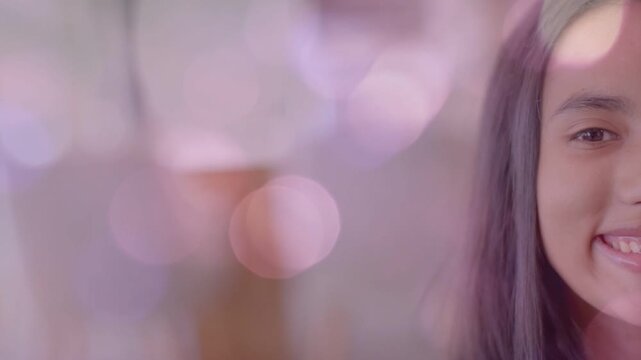 Teen female smiling while camera settling into closeup, pastel bokeh shifting for marketing