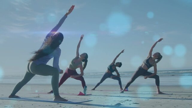 Lead woman leading yoga lunge stretch for fitness, group mirroring on beach, bokeh overlay moving