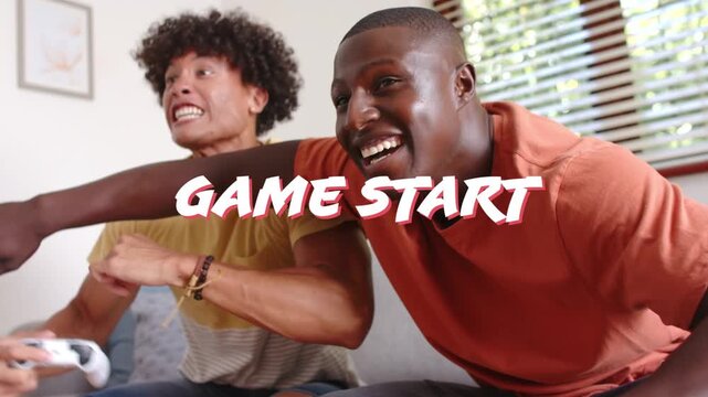 Two men sitting on couch, reacting to GAME START, lunging, gripping white controllers for match