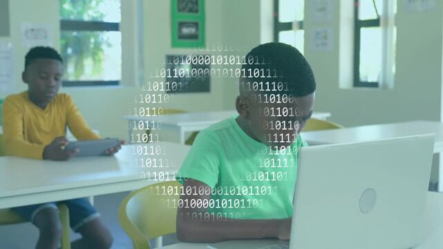 Green-tee boy closing laptop showing logo while binary overlay appearing, peer on tablet, classroom