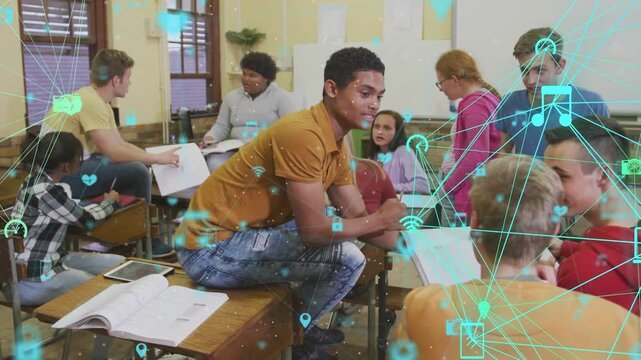 Teen male in mustard polo gesturing, leading peers in classwork, teal icons drifting over group