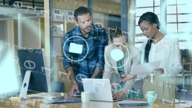 Business trio around laptop, lead woman typing and causing icons streaming over tablet for review