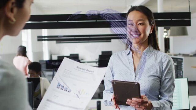 Manager tapping tablet and causing globe overlay rotating over quarter report to show business data