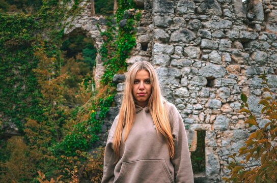 Portrait of a young woman with historic stone ruins of Samobor Castle in the background, Croatia. A visually rich combination of culture, heritage, and modern lifestyle&mdash;ideal for travel marketing.