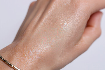 Fototapeta premium Oily skin hand close up pores reflective skincare texture natural moisture cosmetic female wrist glossy hydration healthy adult light beige detail macro