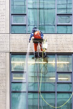 Window cleaner ropes down a high-rise building, Seattle, Washington, USA