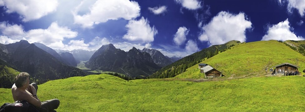 Hiker, panoramic view of a verdant alpine pasture set against a deep blue sky, Ahornboden, Tirol, Austria, Europe