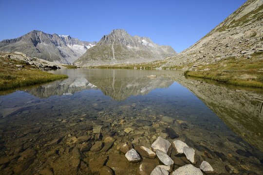 Mt. Aleschhorn and Mt. Olmenhorn are reflected in a small lake, Fiesch, Valais, Switzerland, Europe