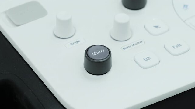 Ultrasound console shows menu button and control keys. Modern diagnostic system presents adjustment panel for gynecology imaging setup