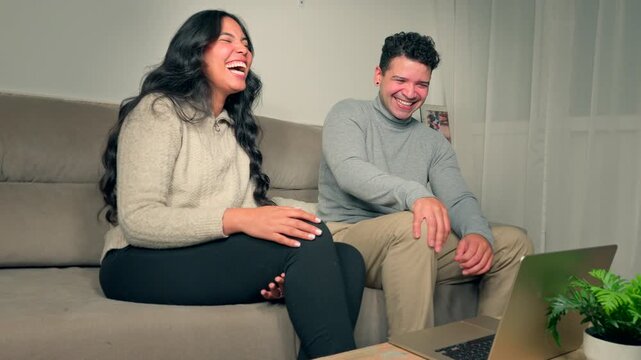 Authentic Smiling Couple Enjoying Funny Content on Laptop Computer Living Room Environment 4K