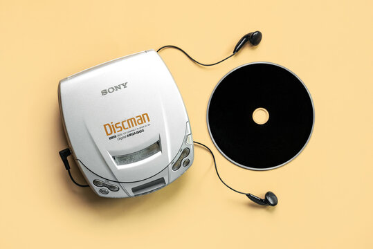 Top view of Sony portable compact disc player Discman with headphones and music CDs. Illustrative editorial