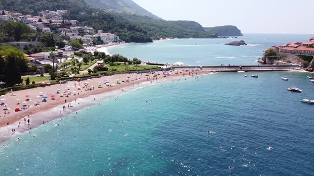 Drone video capturing the serene beauty of Sveti Stefan Island, Montenegro turquoise waters, sunlit beaches, and the magic of a hidden Adriatic paradise