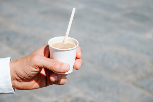 close-up of a man holding a takeaway cortado
