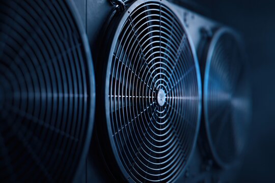 Cooling fans on industrial server hardware working to maintain optimal temperature in a modern data center or cryptocurrency mining rig