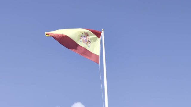 Movimiento suave de bandera espa&ntilde;ola contra nubes