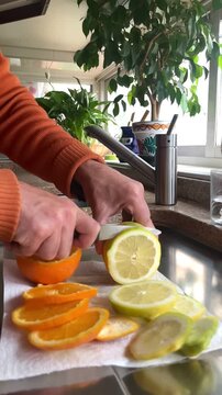 Cortando en rodajas lim&oacute;n de fruta con cuchillo lemon fruit knife slice en cocina de casa elaborando limonada c&oacute;ctel para exprimir