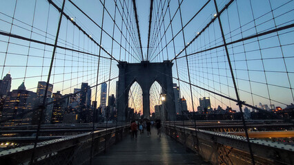 Fototapeta premium Twilight over Manhattan: The Brooklyn Bridge Suspension Cables and Lower Manhattan Skyline at Dusk