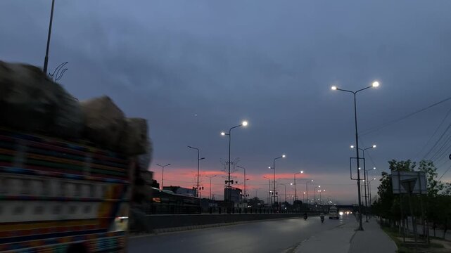 vehicle speeding on a highway at dusk under dramatic cloudy sky