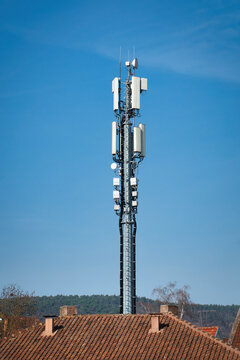 Teleaufnahme eines Mobilfunkmastes auf einem Hausdach