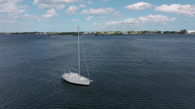 Drone going east from Summa Beach Park passing close to a lone moored sailboat in the ICW.