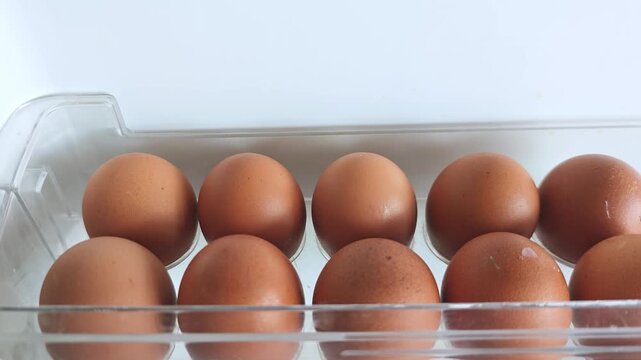 Brown eggs arranged in a clear plastic container, showing a gradual shift in positioning and visibility from left to right across three sequential frames
