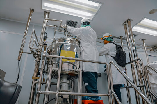 Male work inspection process stainless steel tanks and pipe with pressure meter in equipment tank facility for milk cellar at the with vertical stainless