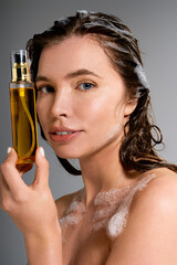 Fototapeta premium Radiant young woman showcases her hair care routine in a bright studio setting