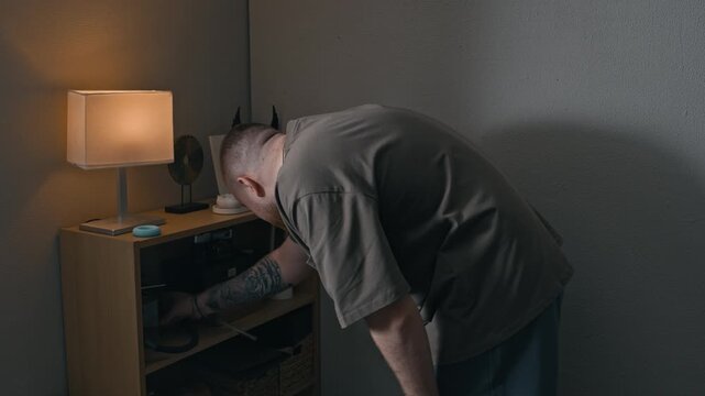 Back view shot of bearded man in apartment playing darts, showing boredom and coping during home restriction
