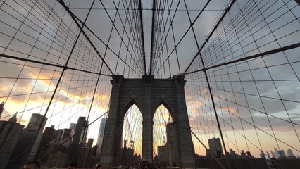 Fototapeta premium Symmetry in Steel: The Brooklyn Bridge Gothic Arch and Suspension Cables at Golden Hour