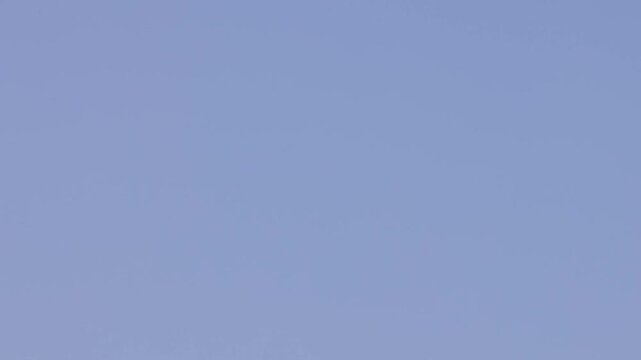 Boeing c17 globemaster military transport aircraft flying through blue sky at low altitude during air show.