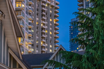 Urban residential towers rising above neighborhood rooftops at dusk © karamysh