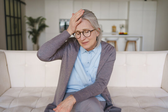 Senior woman suffering from headache at home, elderly health problem, pain, stress, fatigue, discomfort, healthcare concept, wellness and medical support need