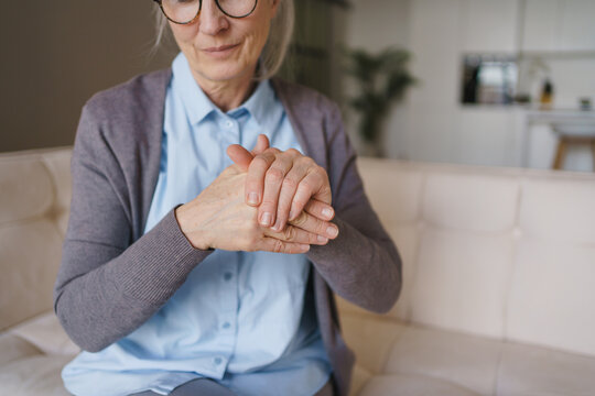 Elderly woman holding painful fingers in close up, arthritis, joint inflammation, stiffness, hand pain, healthcare issue, rehabilitation, wellness and medical care concept