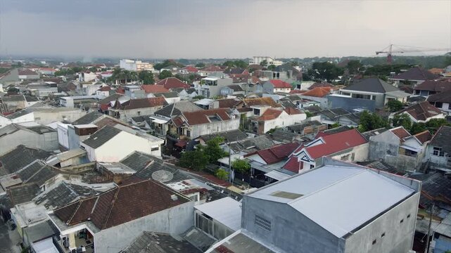 4K aerial image of a densely populated residential neighborhood in an Indonesian city under cloudy skies