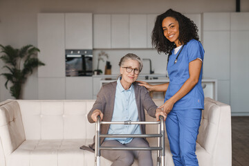 Fototapeta premium Nurse assisting senior woman with walking frame at home, elderly care, mobility support, rehabilitation, caregiver assistance, recovery and healthcare service concept