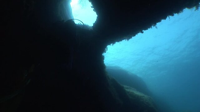 cave diving underwater scuba divers exploring cave dive with torch light in cavern ocean scenery