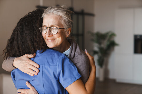 Nurse embracing senior woman at home, elderly support, healthcare service, trust, empathy, emotional wellbeing, caregiver assistance and comfort living concept copy space