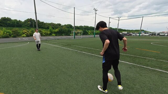 パス練習をする若い男性サッカーコーチ