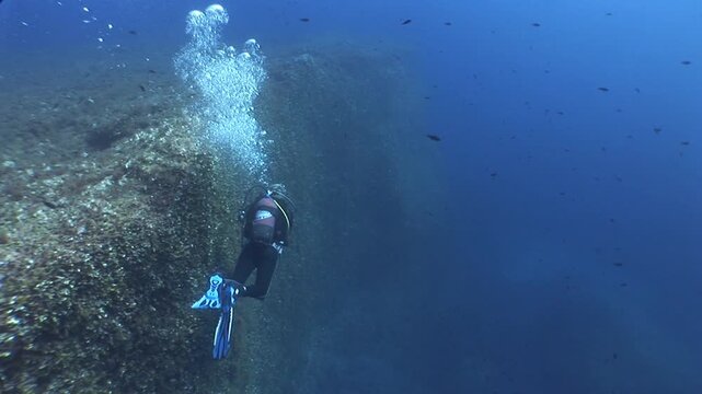 scuba divers are swimming next to walls underwater wall dive