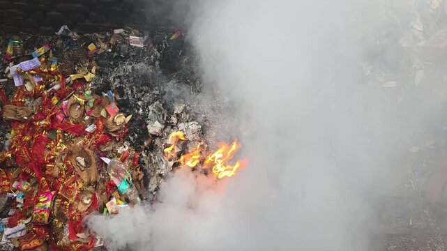 Fire burning waste with colorful offerings in Bhimtal