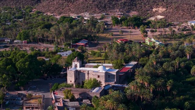 See the stunning aerial views of Mission Church surrounded by the oasis in San Ignacio, Baja California, Mexico showcasing the landscape.