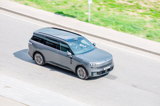 Lynk & Co 900 full-size luxury crossover SUV drive fast on street. Above front side view